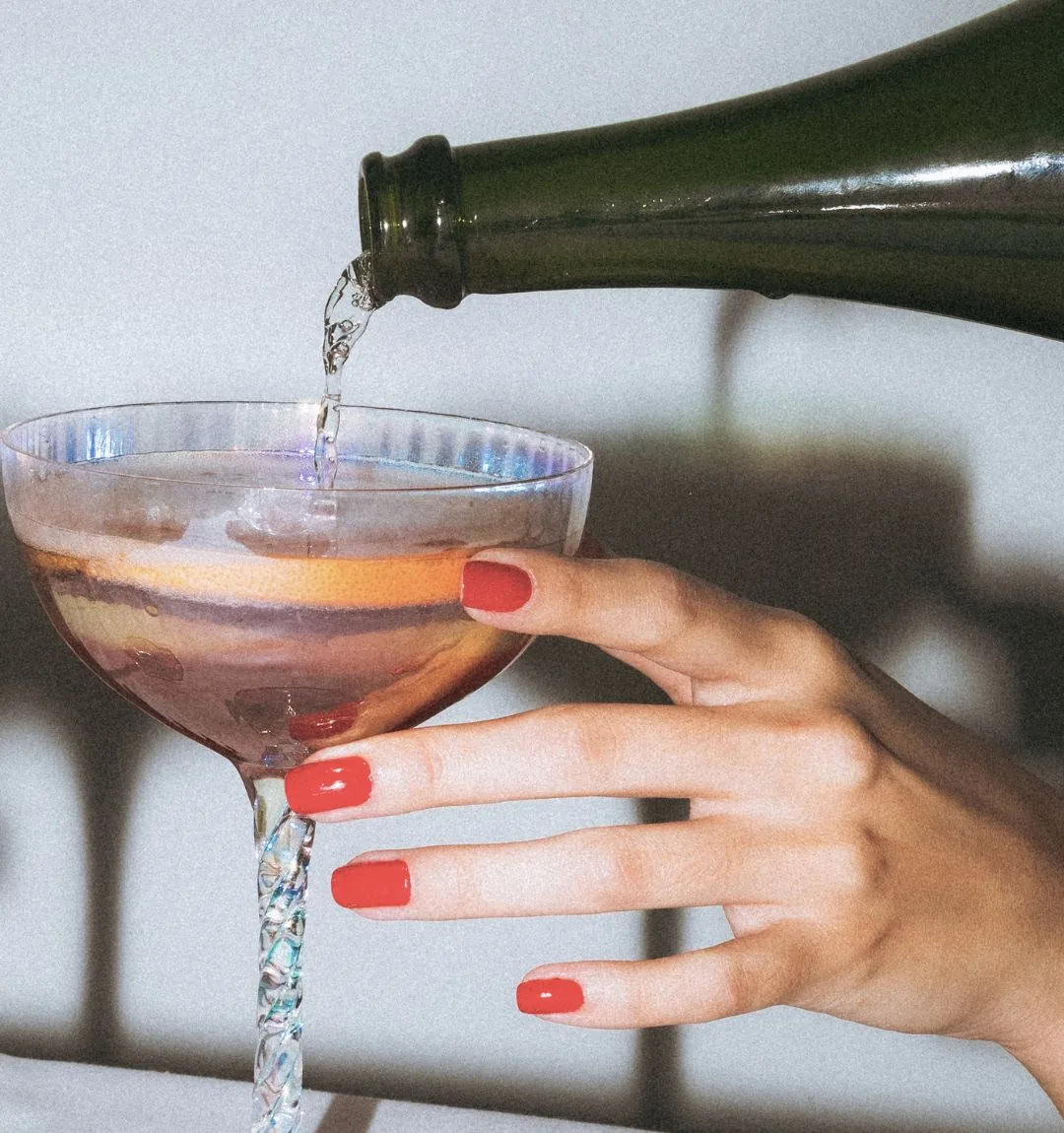 Prosecco being poured into a coupe glass at Dr Rhead Aesthetics.